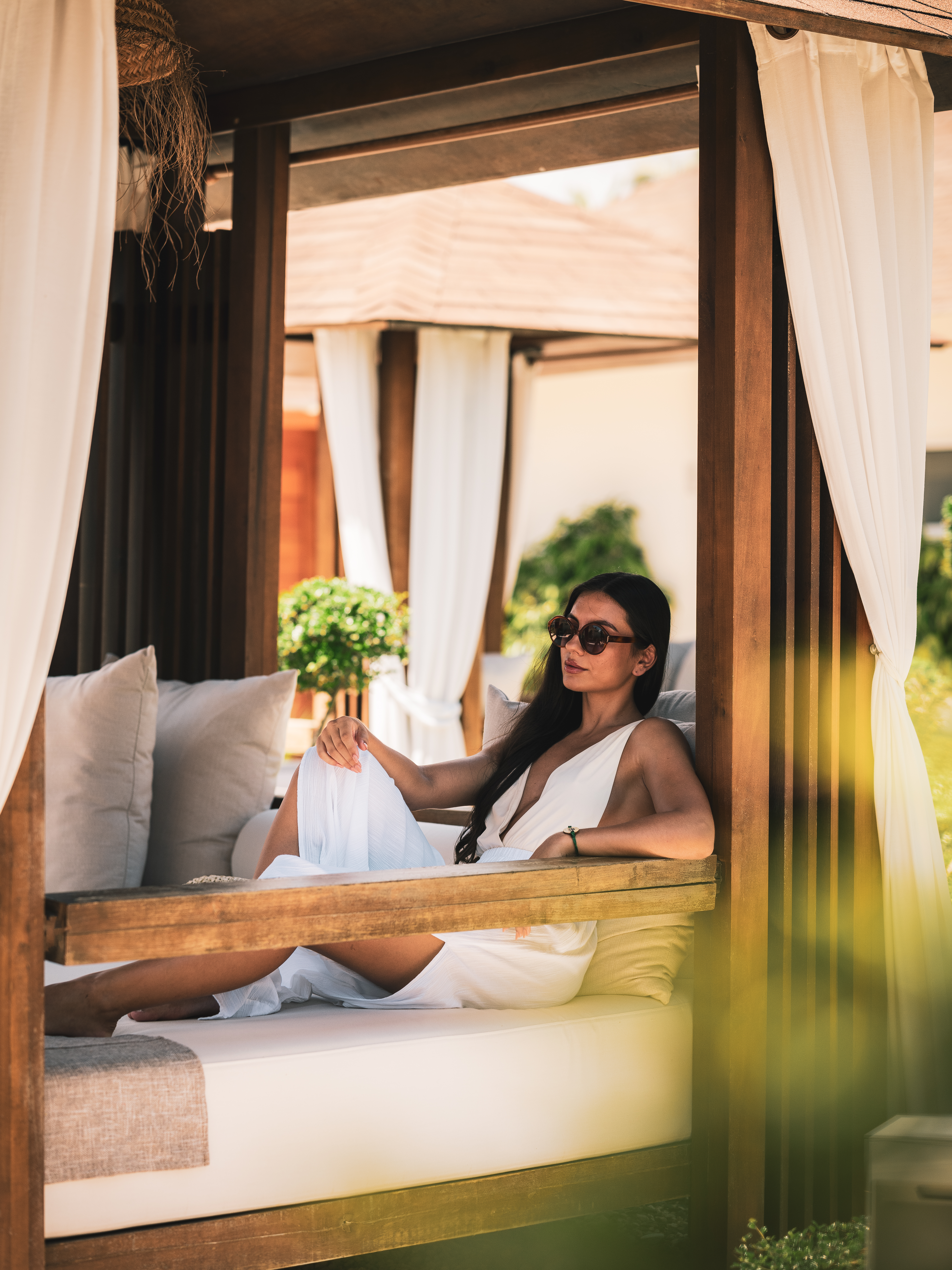 a woman in a white dress sitting on a bench