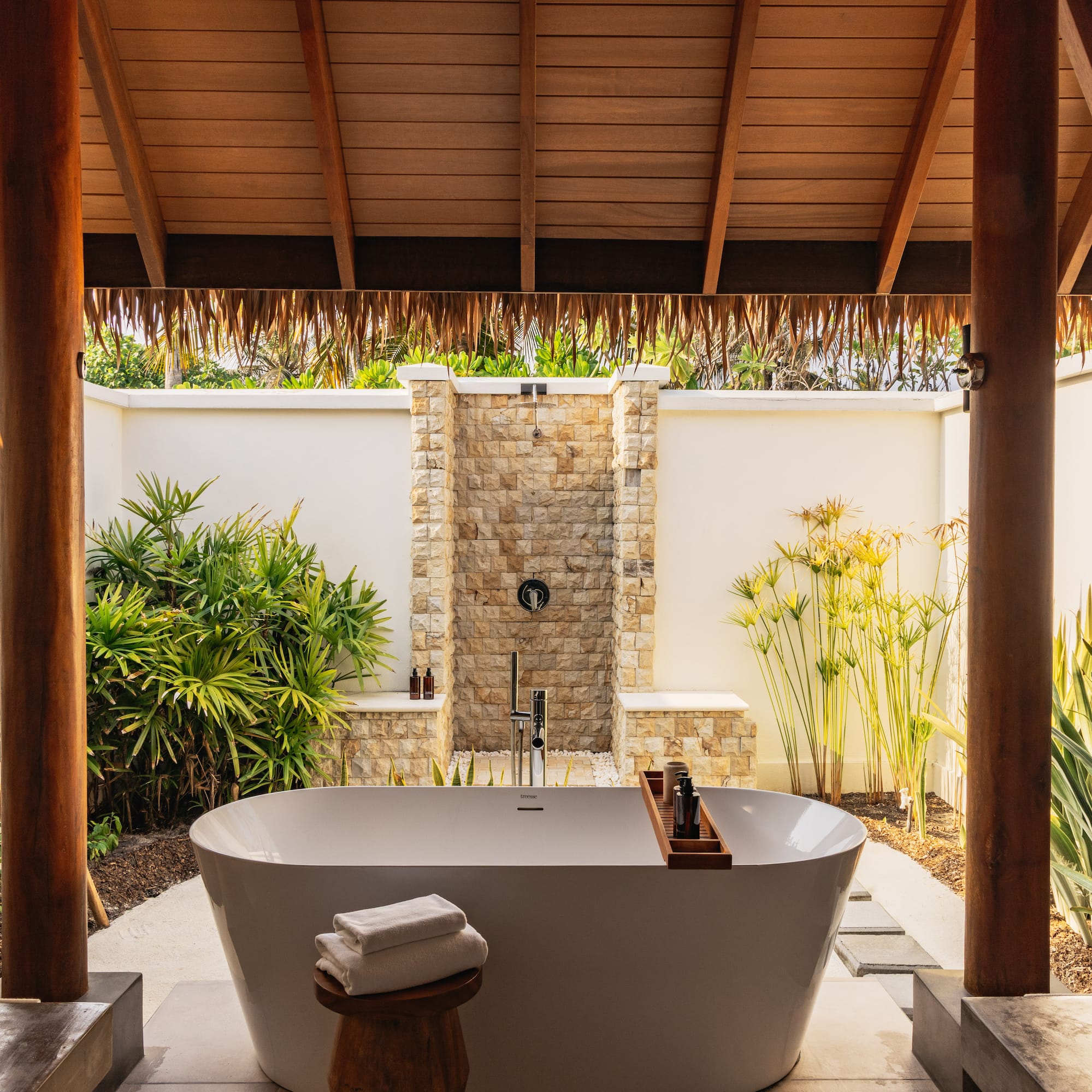 a bathroom with a tub and a stool