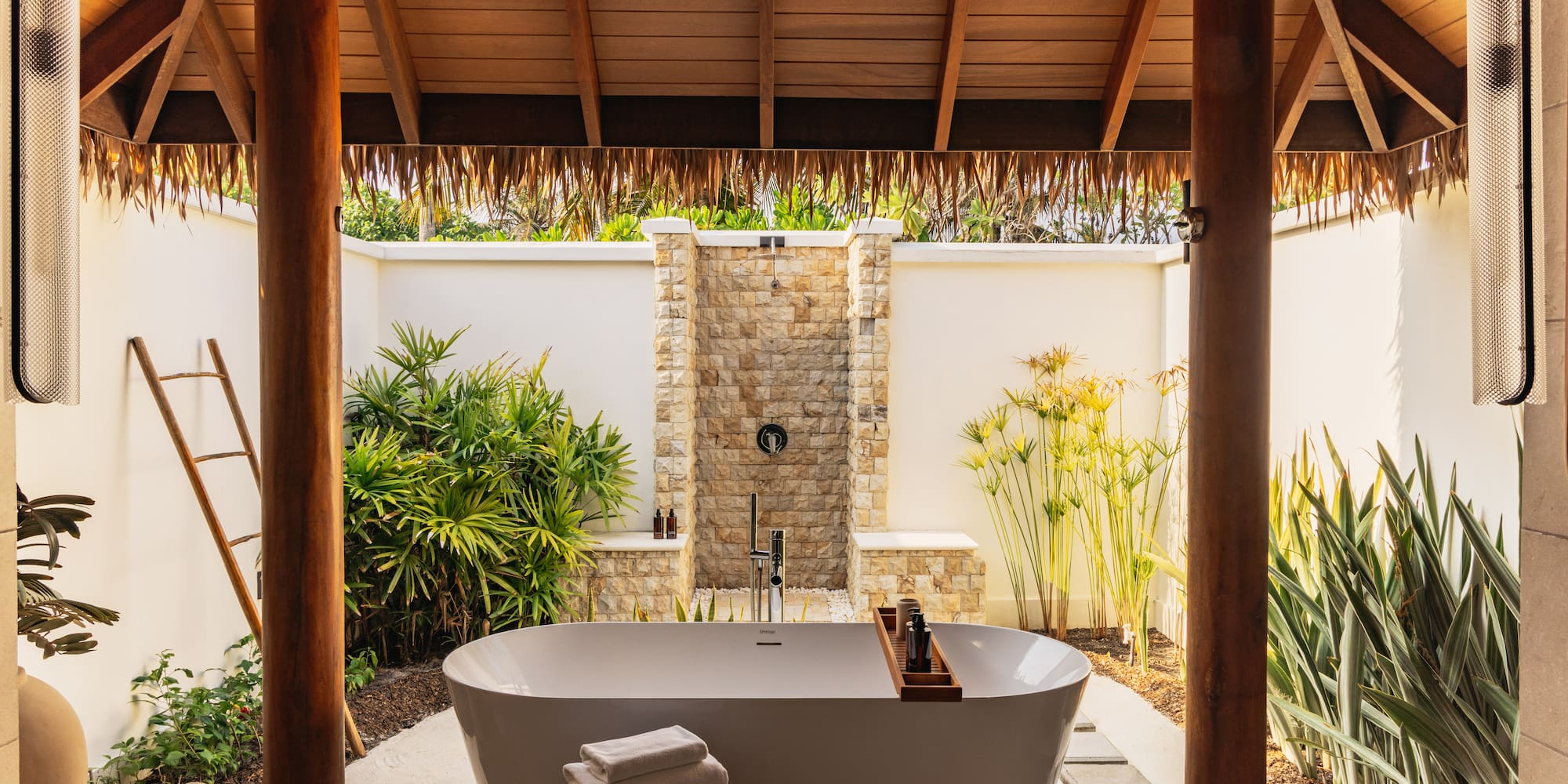 a bathtub outside with a shower