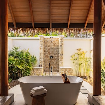 a bathtub outside with a shower