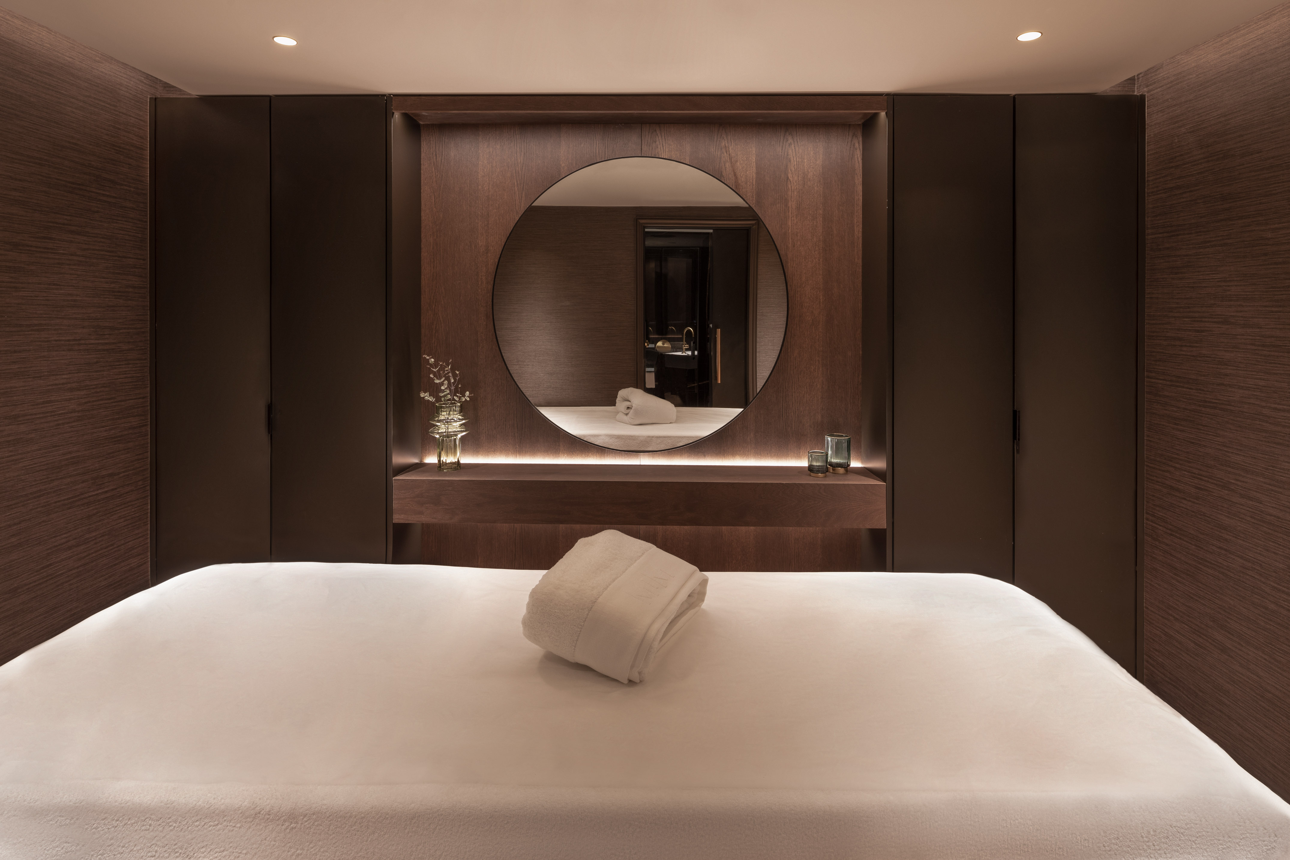 a bed with a round mirror in the background