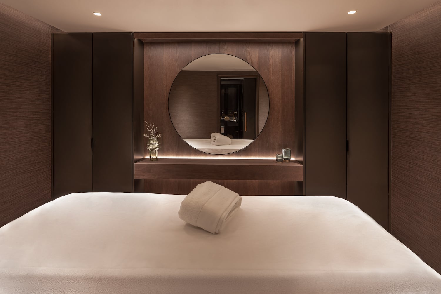 a bed with a round mirror in the background