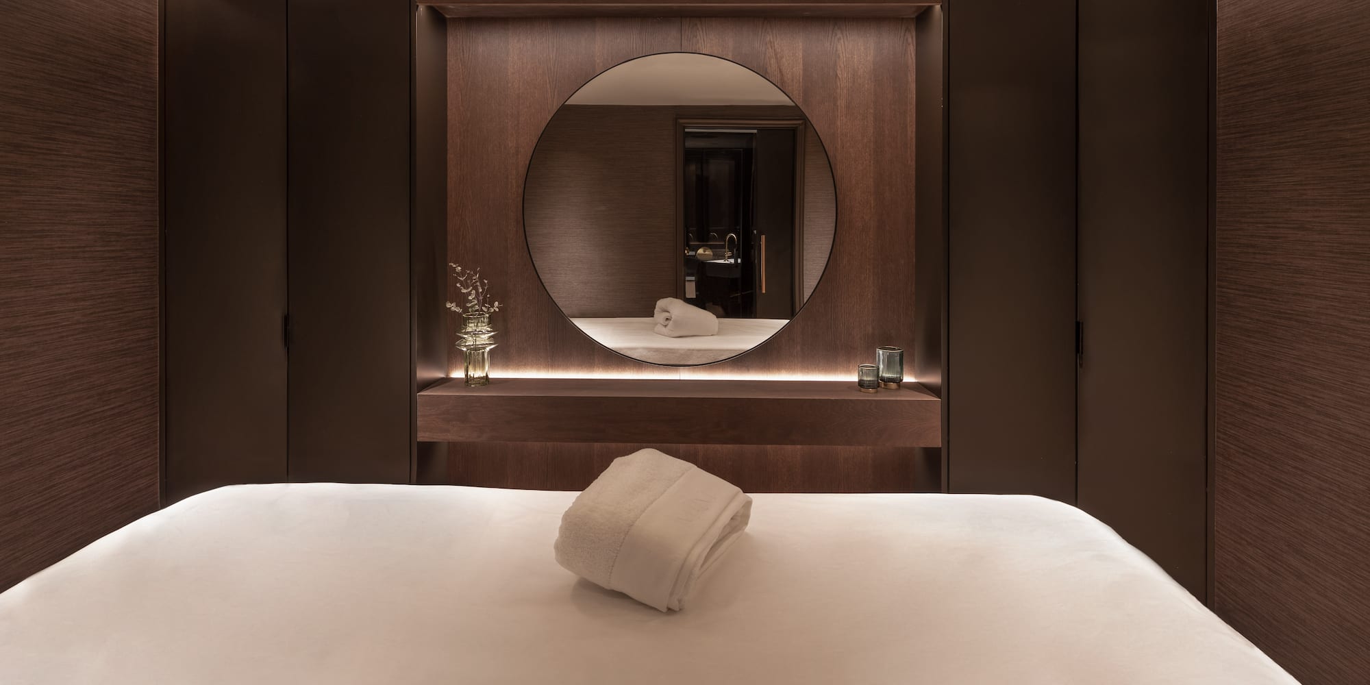 a bed with a round mirror in the background