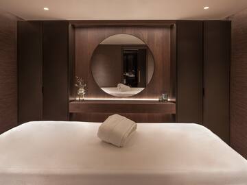 a bed with a round mirror in the background