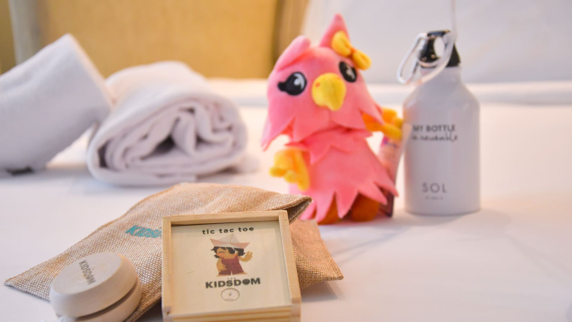 a stuffed animal next to a towel and a bottle