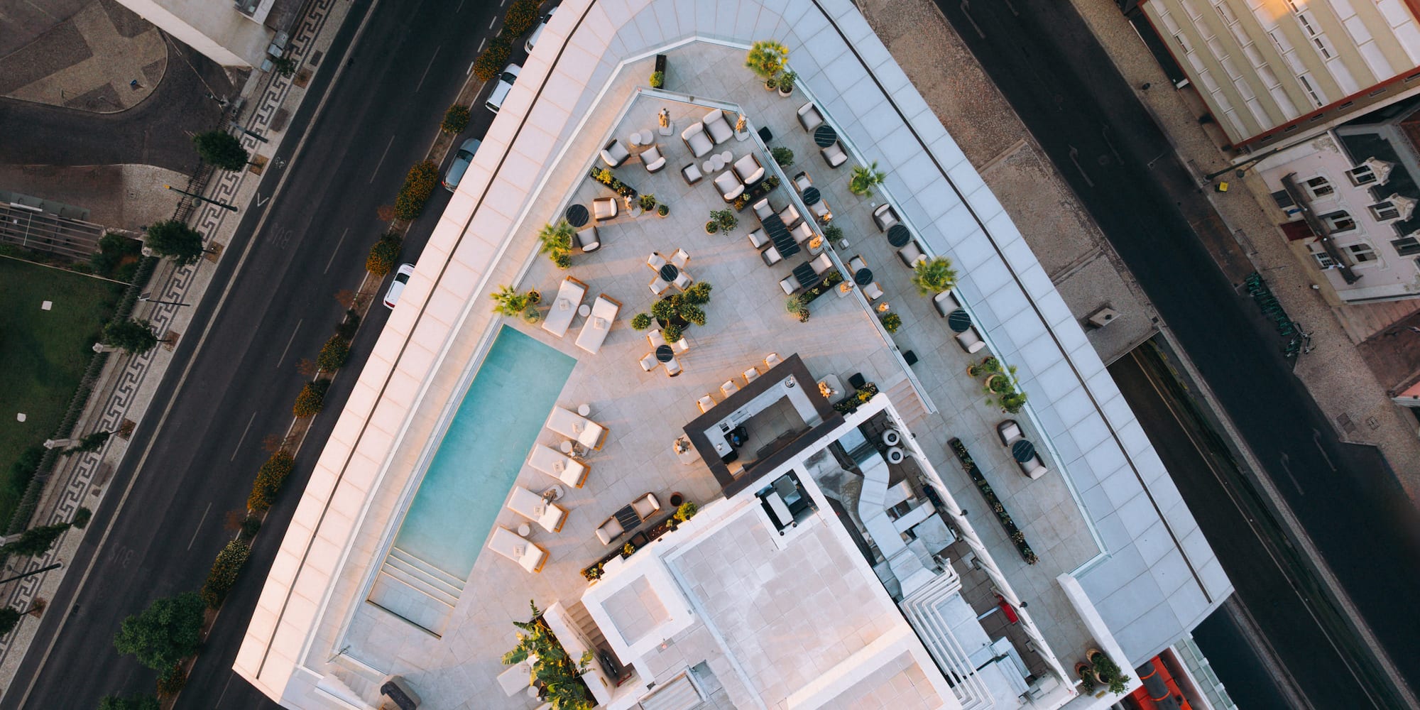 a rooftop of a building with a pool and chairs