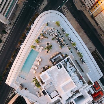 a rooftop of a building with a pool and chairs