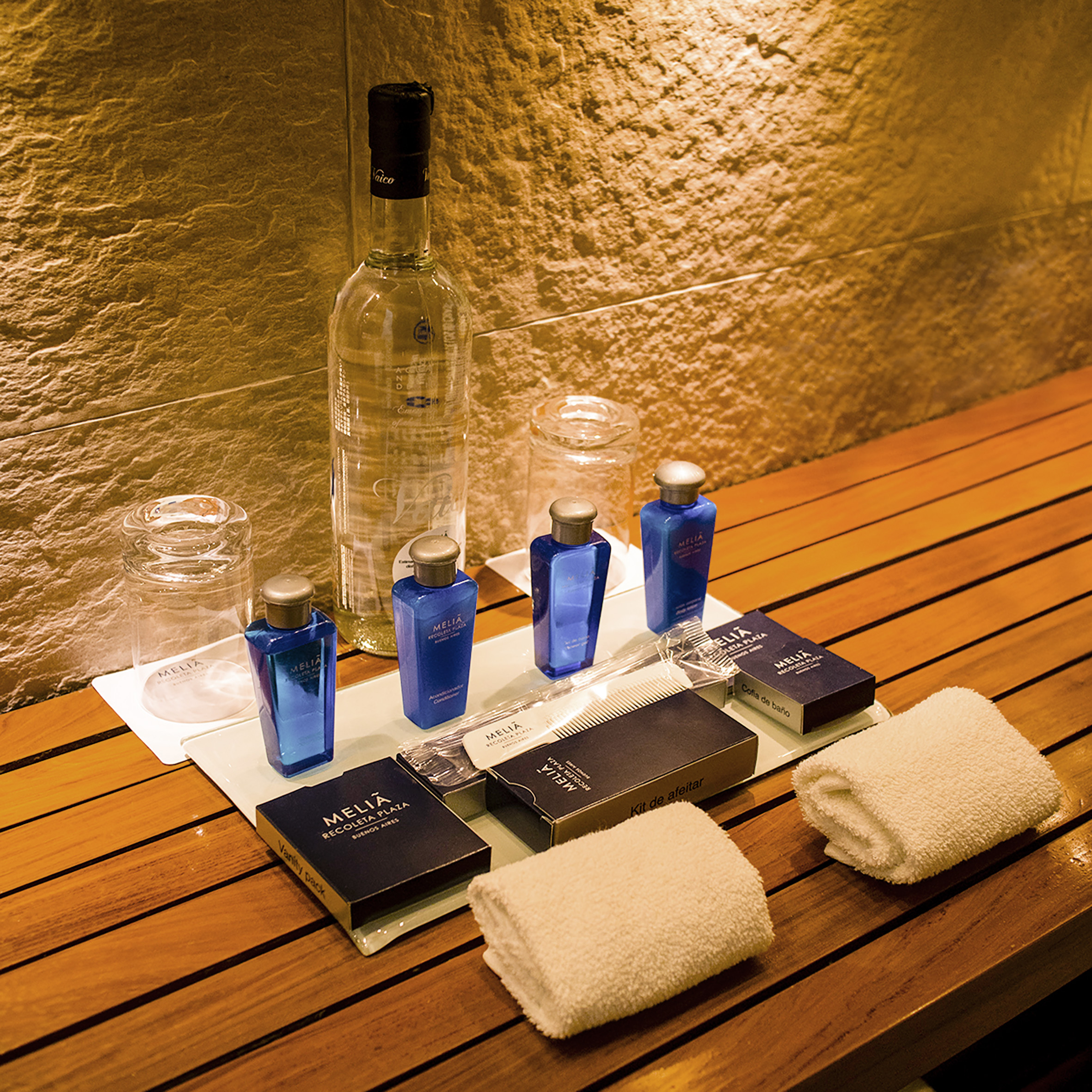 Meliá Recoleta Plaza hotel toiletries, water, and towels on a wooden vanity.