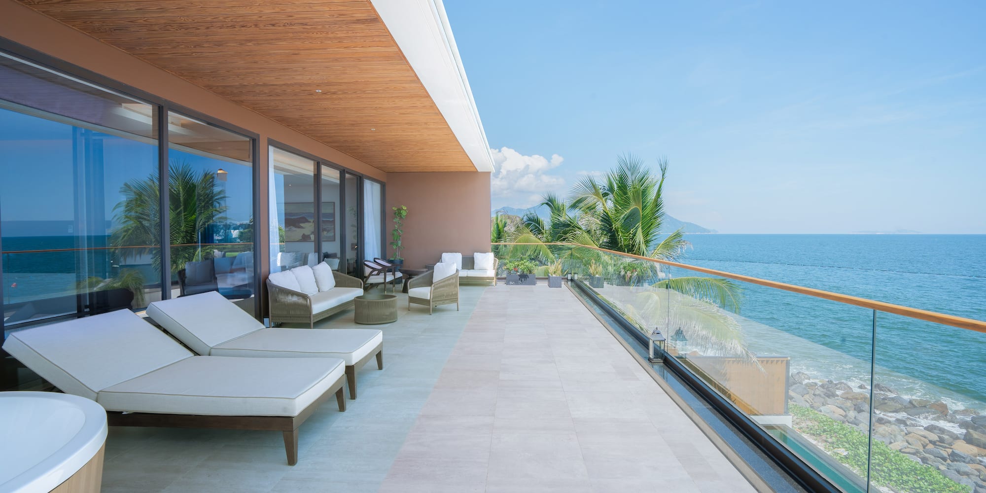 a deck with chairs and a view of the ocean