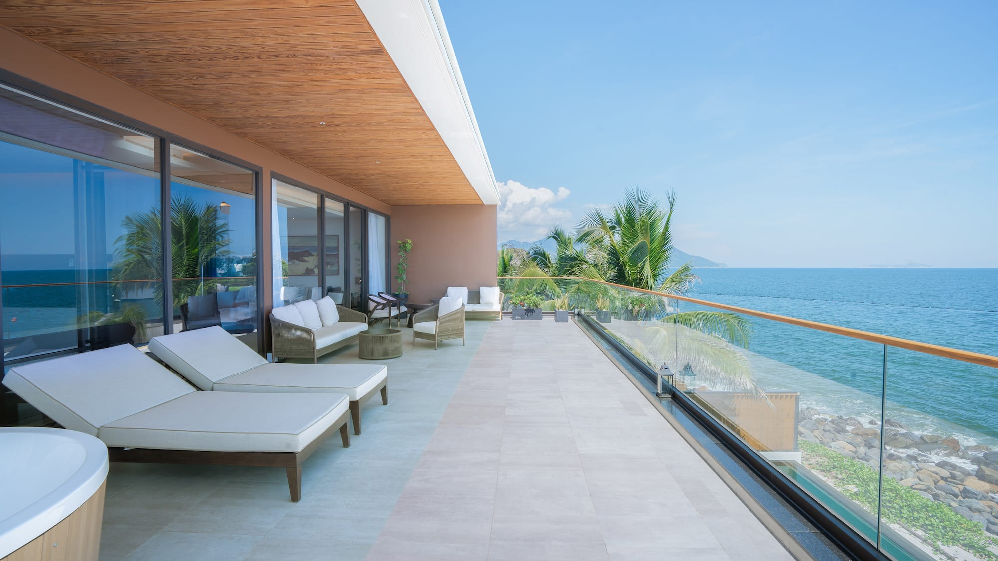 a deck with chairs and a view of the ocean
