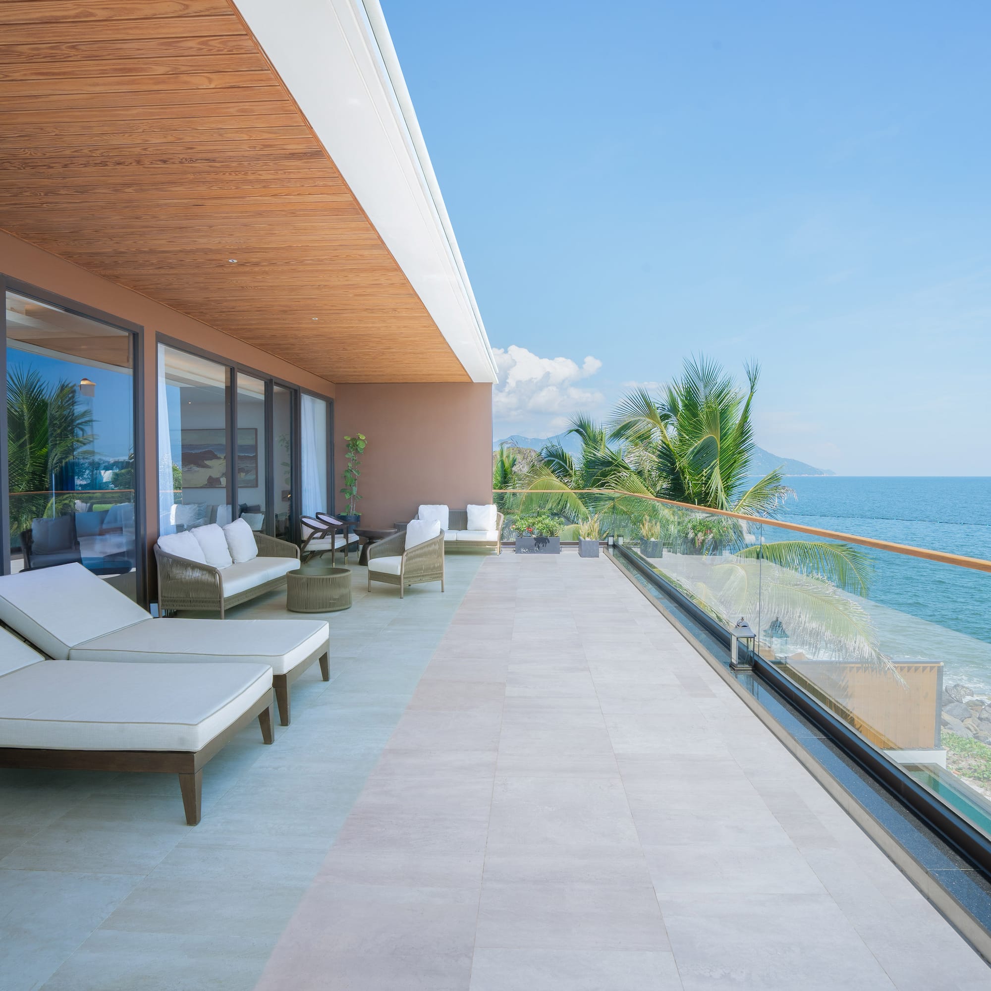a deck with chairs and a view of the ocean