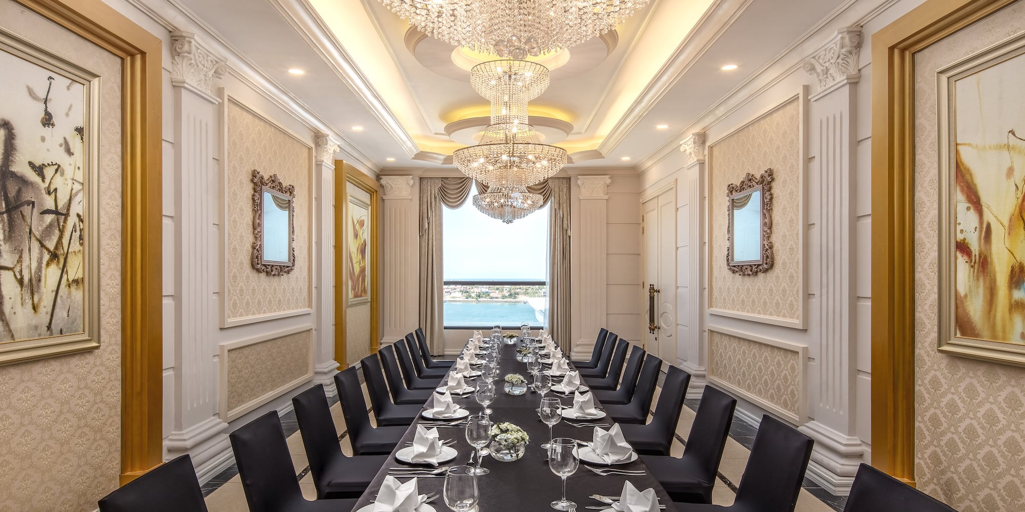 a long table with black chairs and plates and glasses