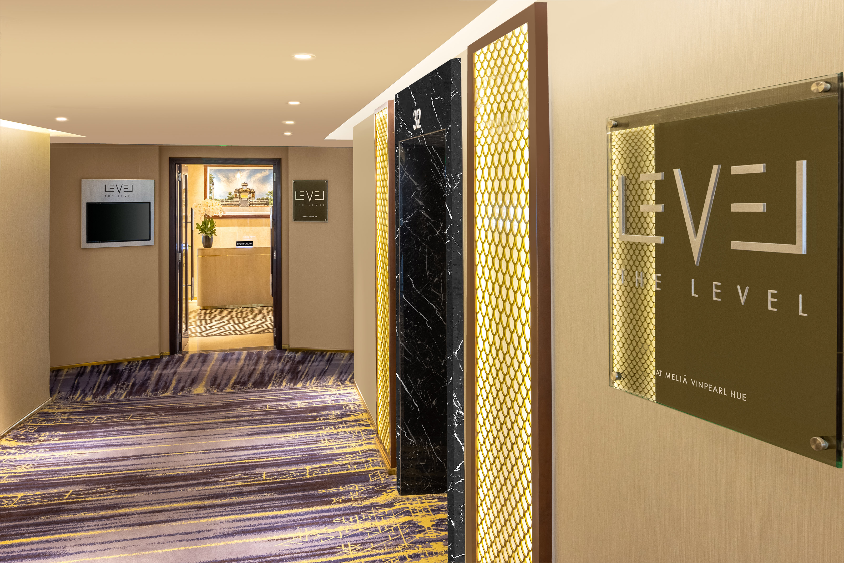 Modern hotel hallway, Melia Vinpearl Hue "THE LEVEL" area, elevator, lounge entrance.