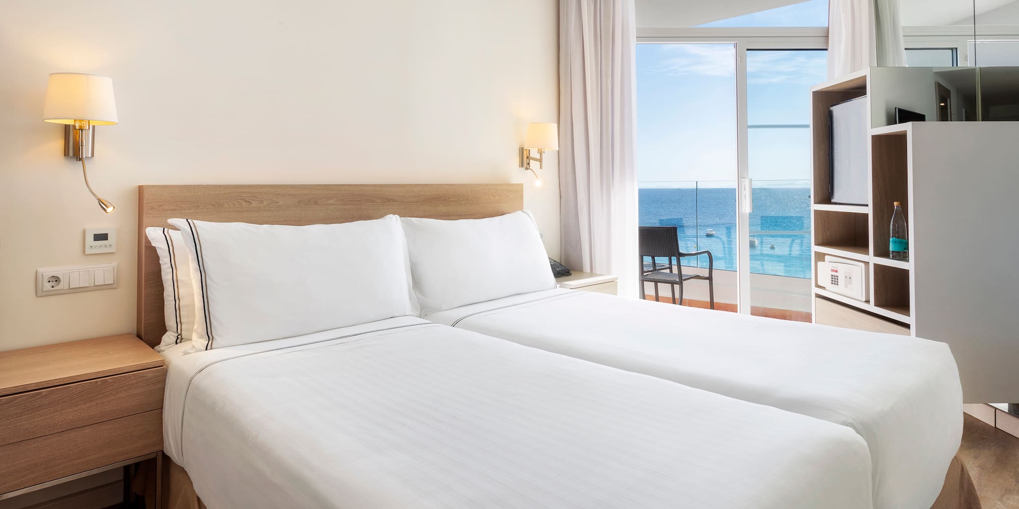 a room with two beds and a glass door