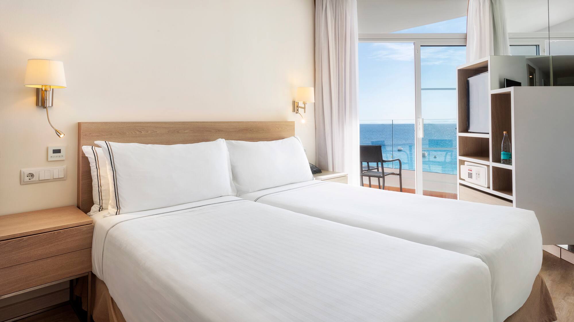 a room with two beds and a glass door