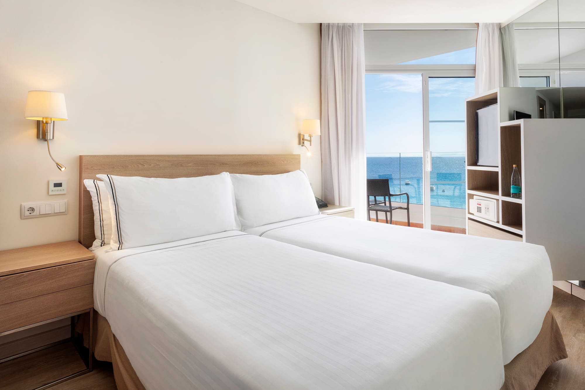 a room with two beds and a glass door