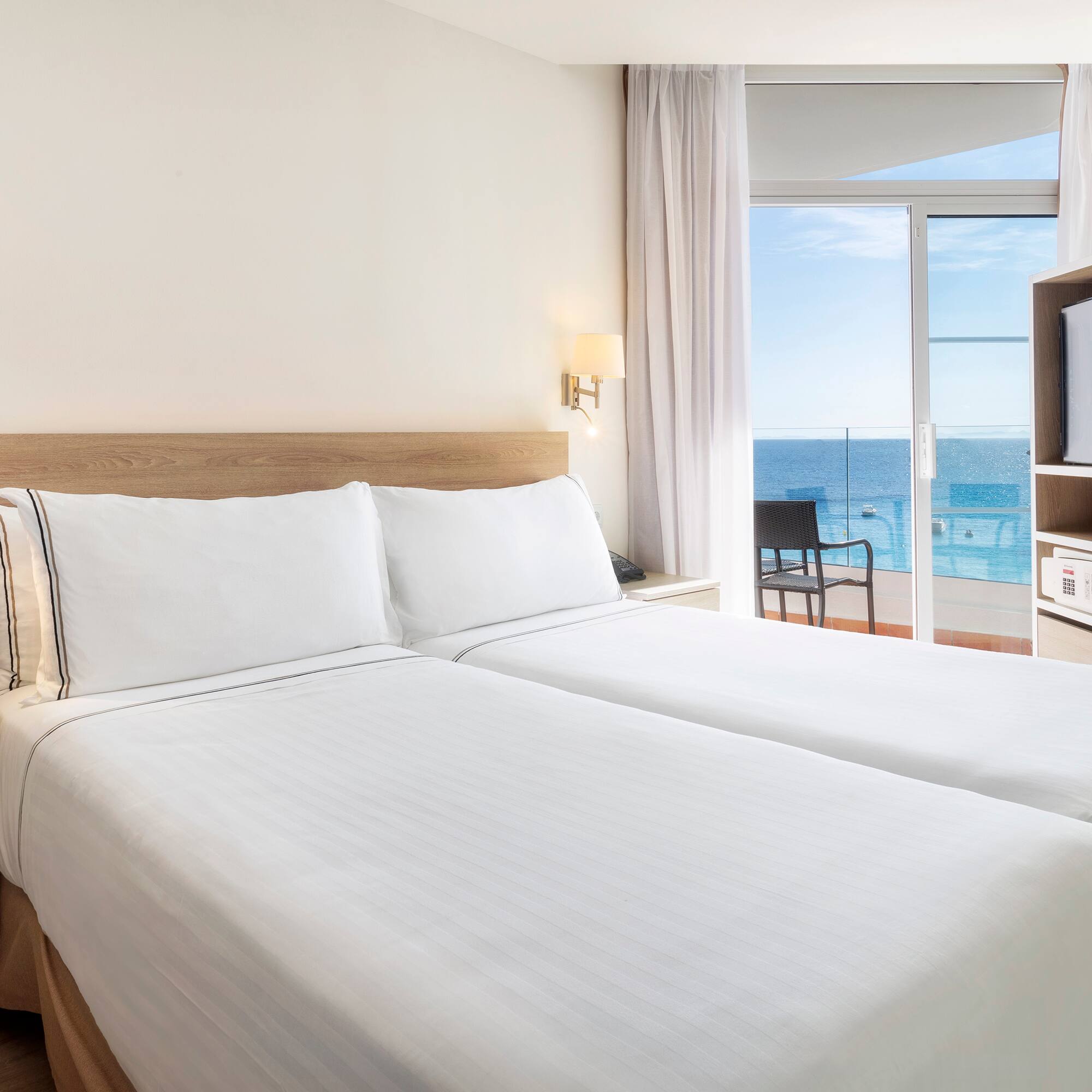 a room with two beds and a glass door