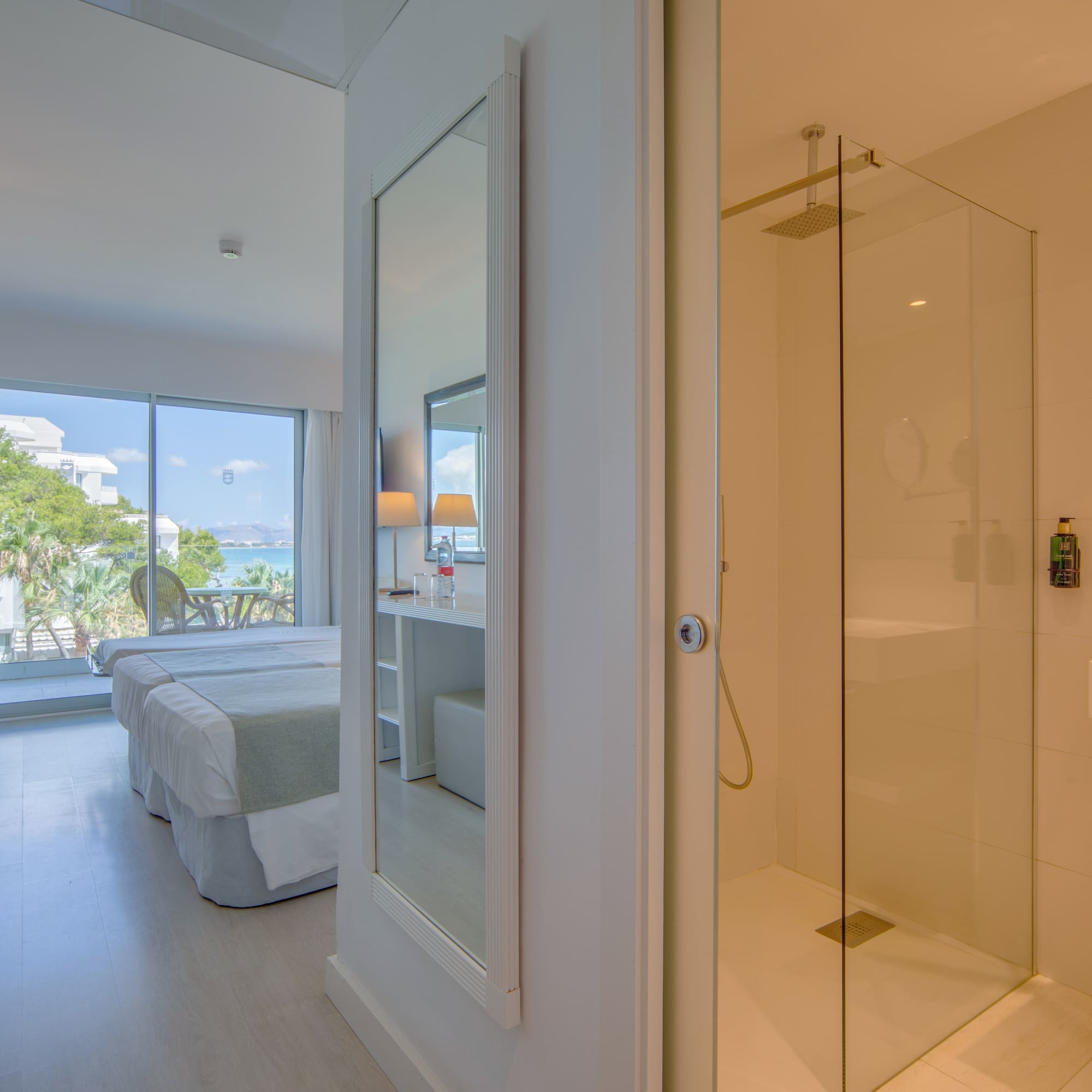 a bathroom with a glass shower and a bed