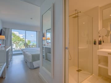 a bathroom with a glass shower and a bed