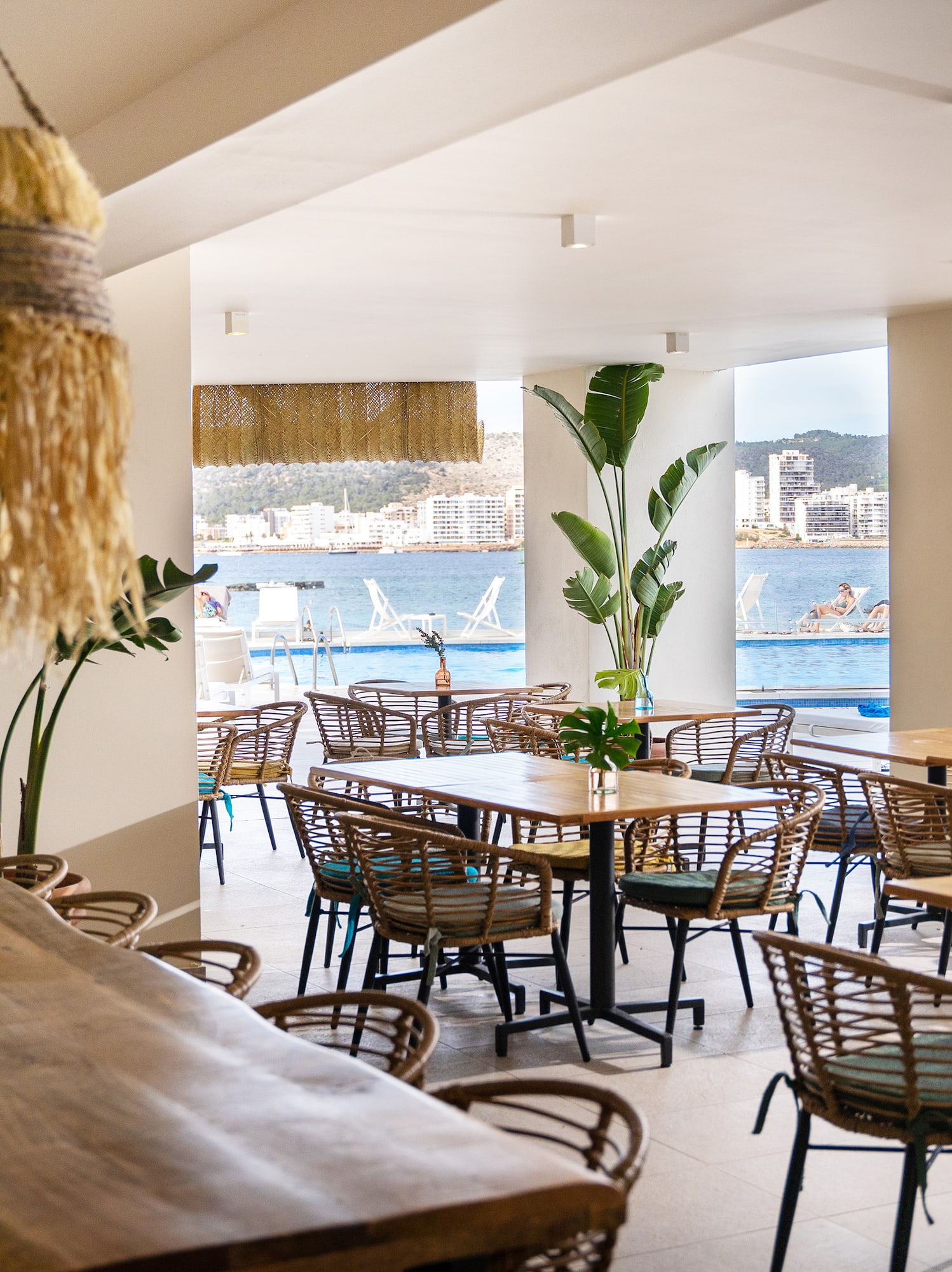 a room with tables and chairs and a large window