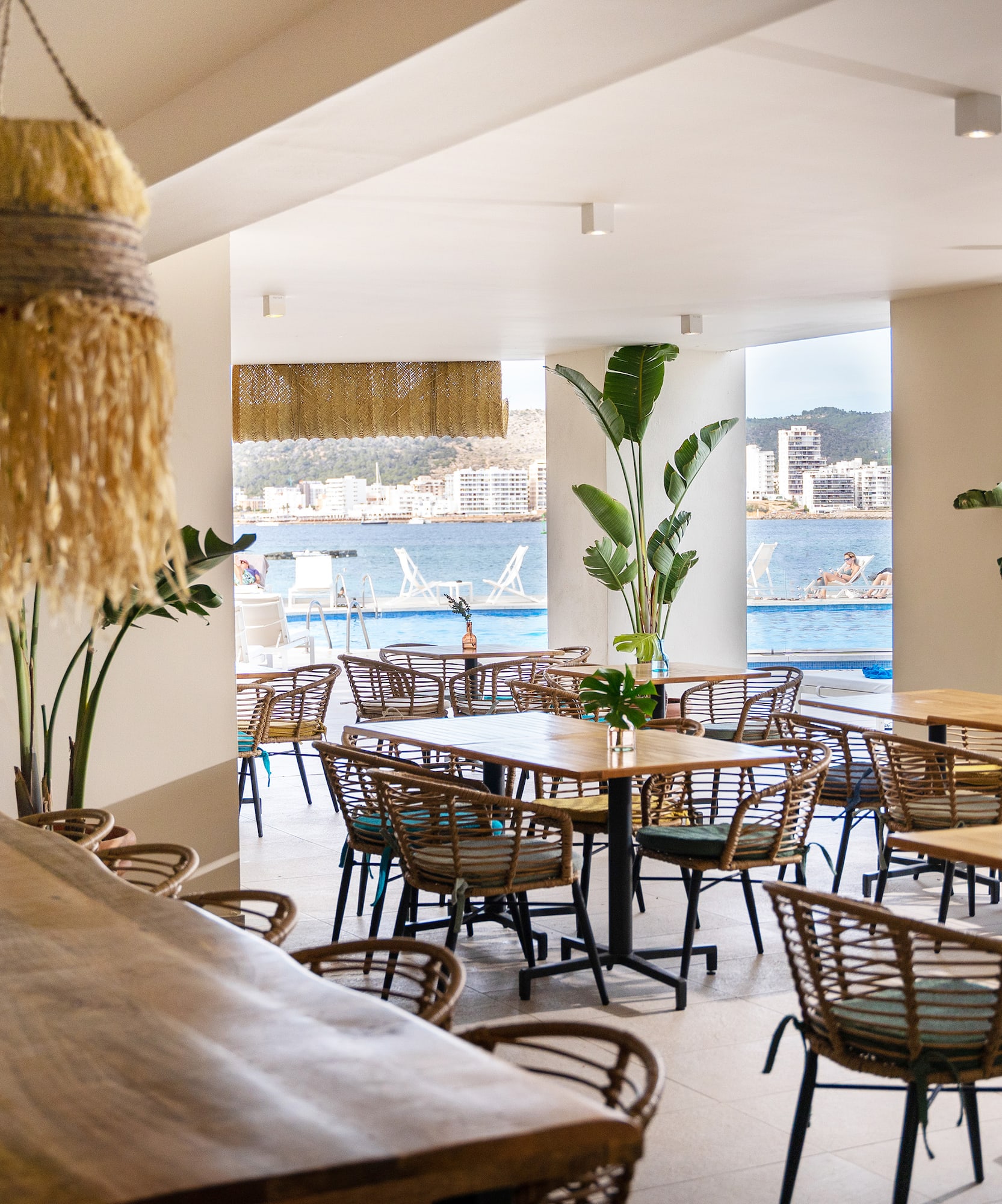 a room with tables and chairs and a large window