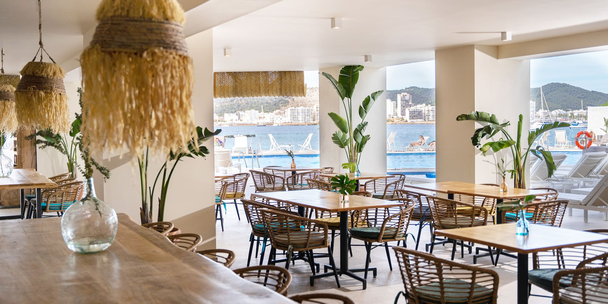 a room with tables and chairs and a large window