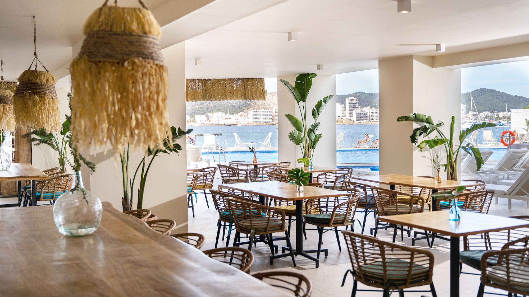 a room with tables and chairs and a large window