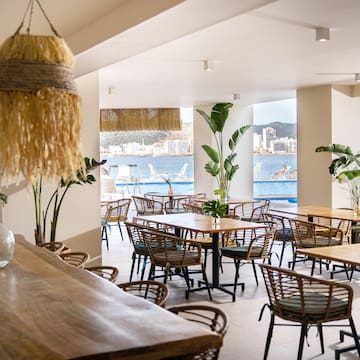 a room with tables and chairs and a large window