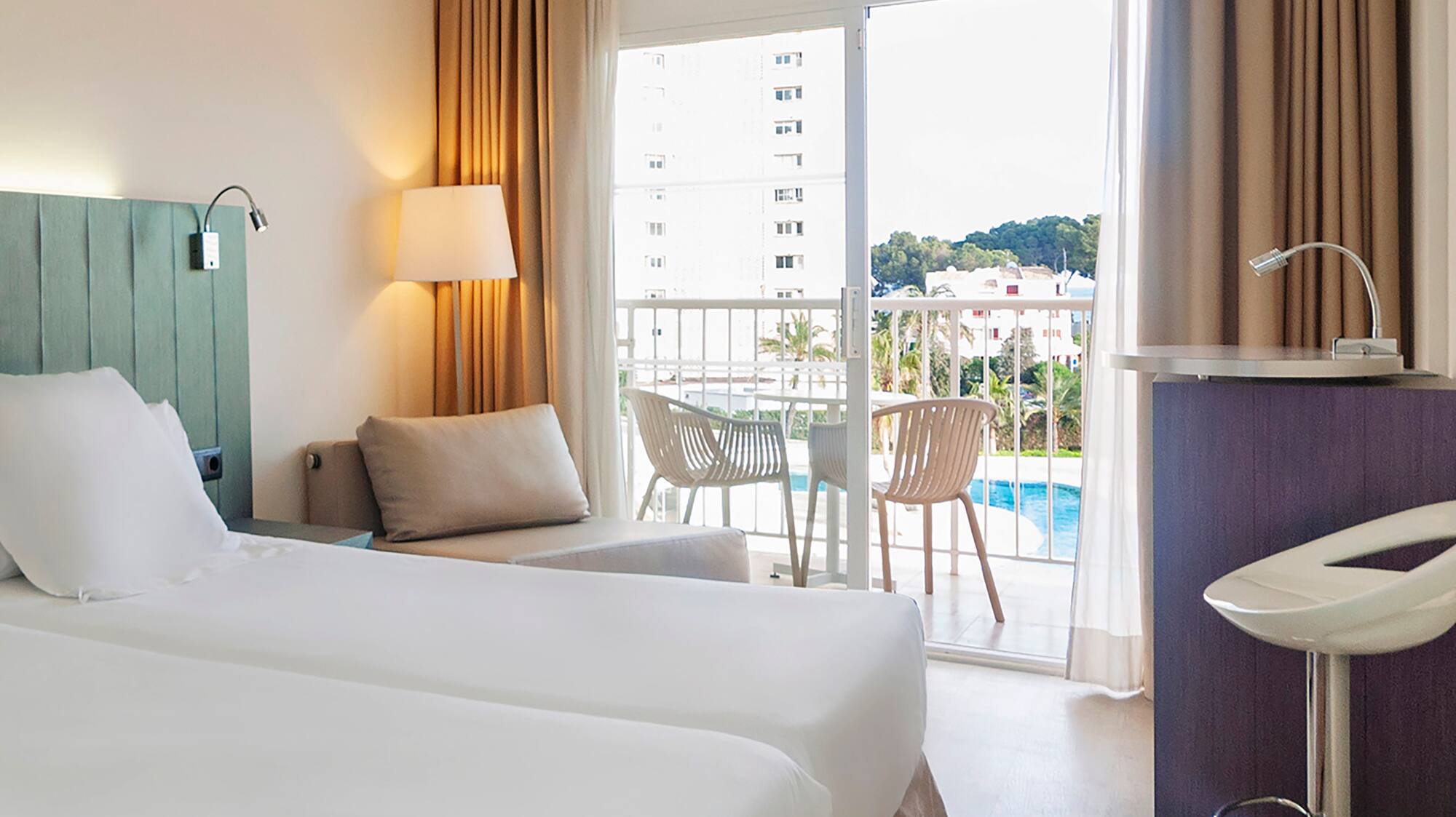 a room with two beds and a table and chairs