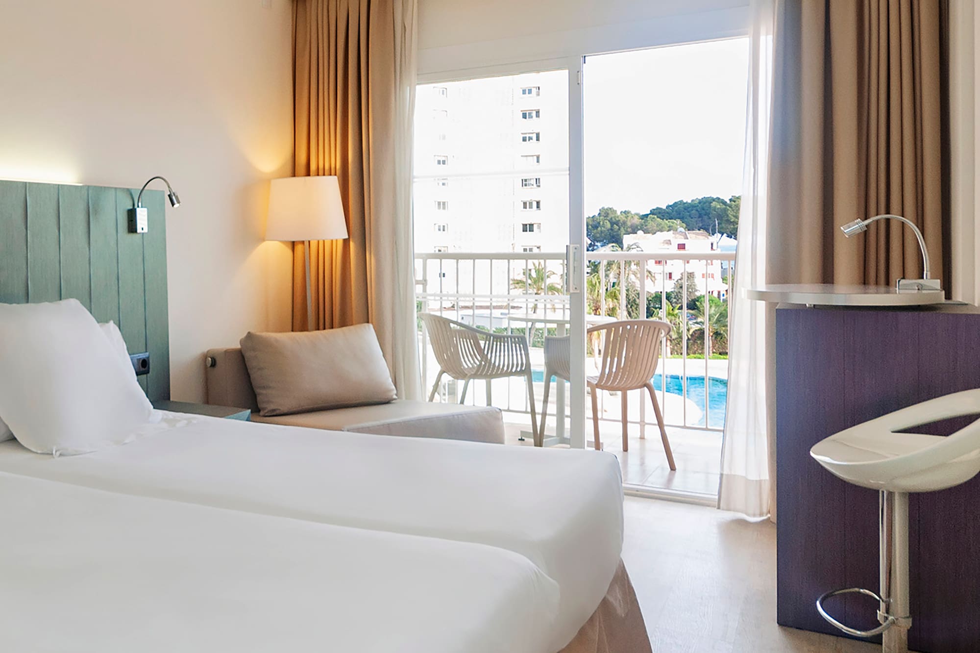 a room with two beds and a table and chairs