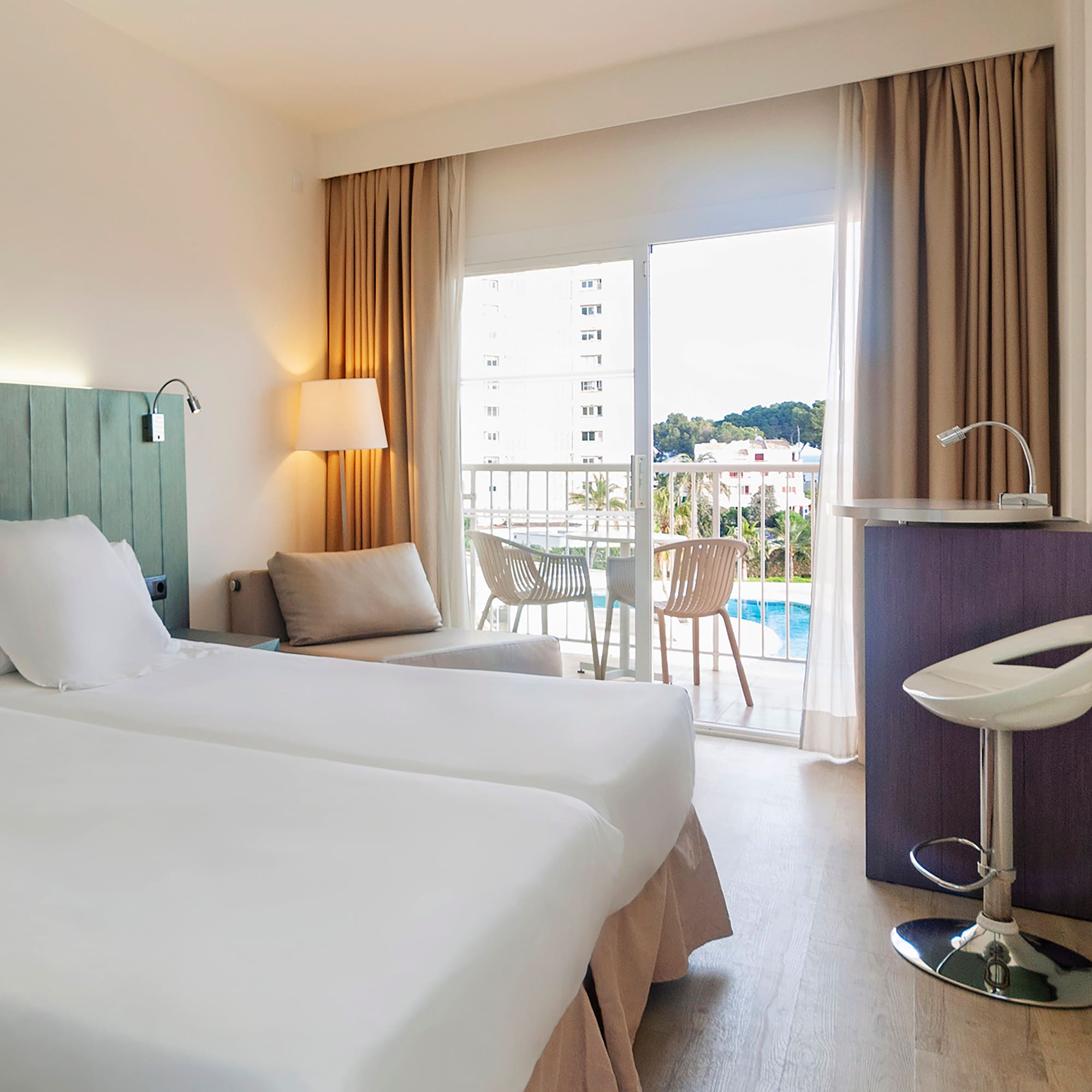 a room with two beds and a table and chairs