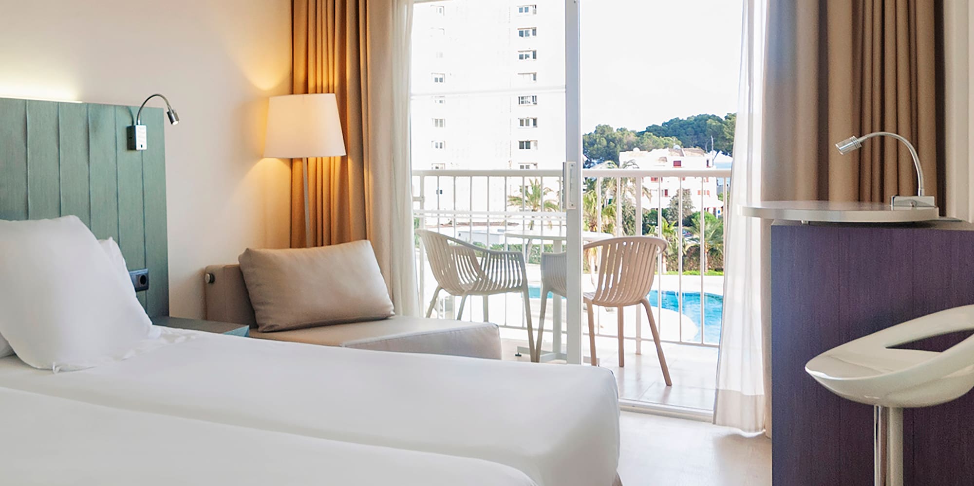 a room with two beds and a table and chairs