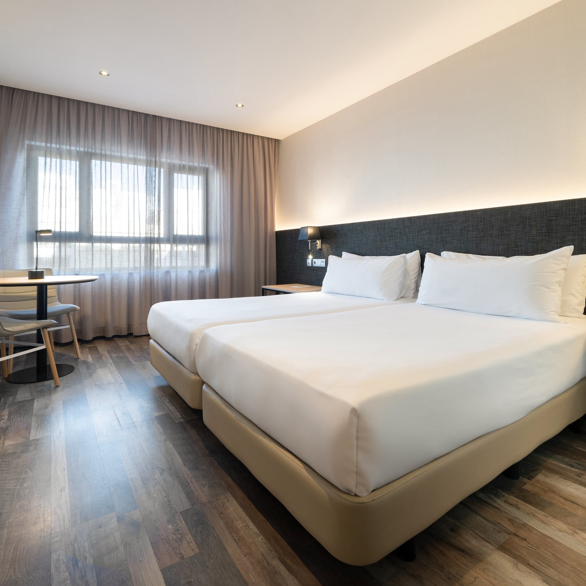 a room with two beds and a table