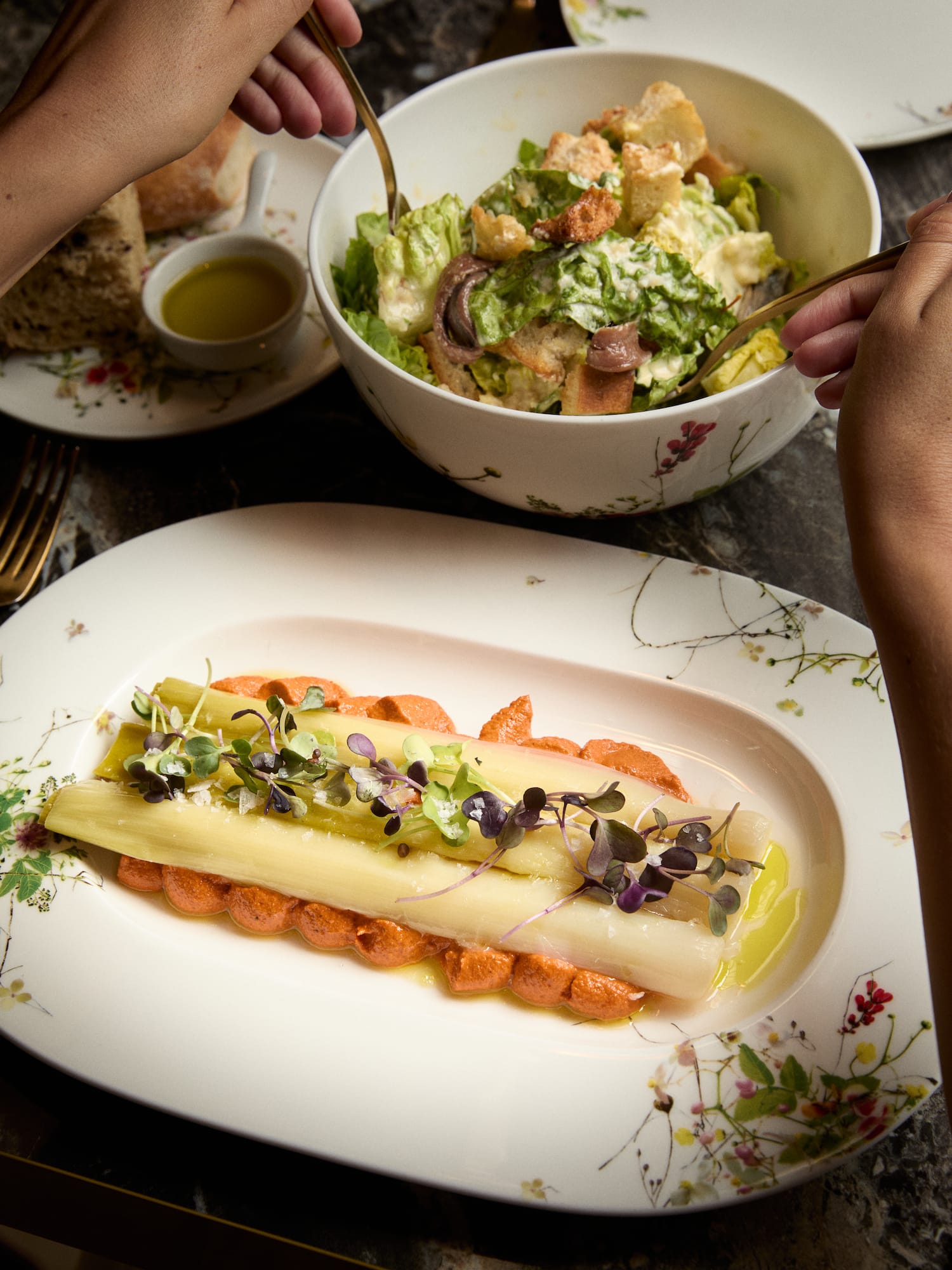 Gourmet white asparagus with red pepper sauce and Caesar salad, fine dining.