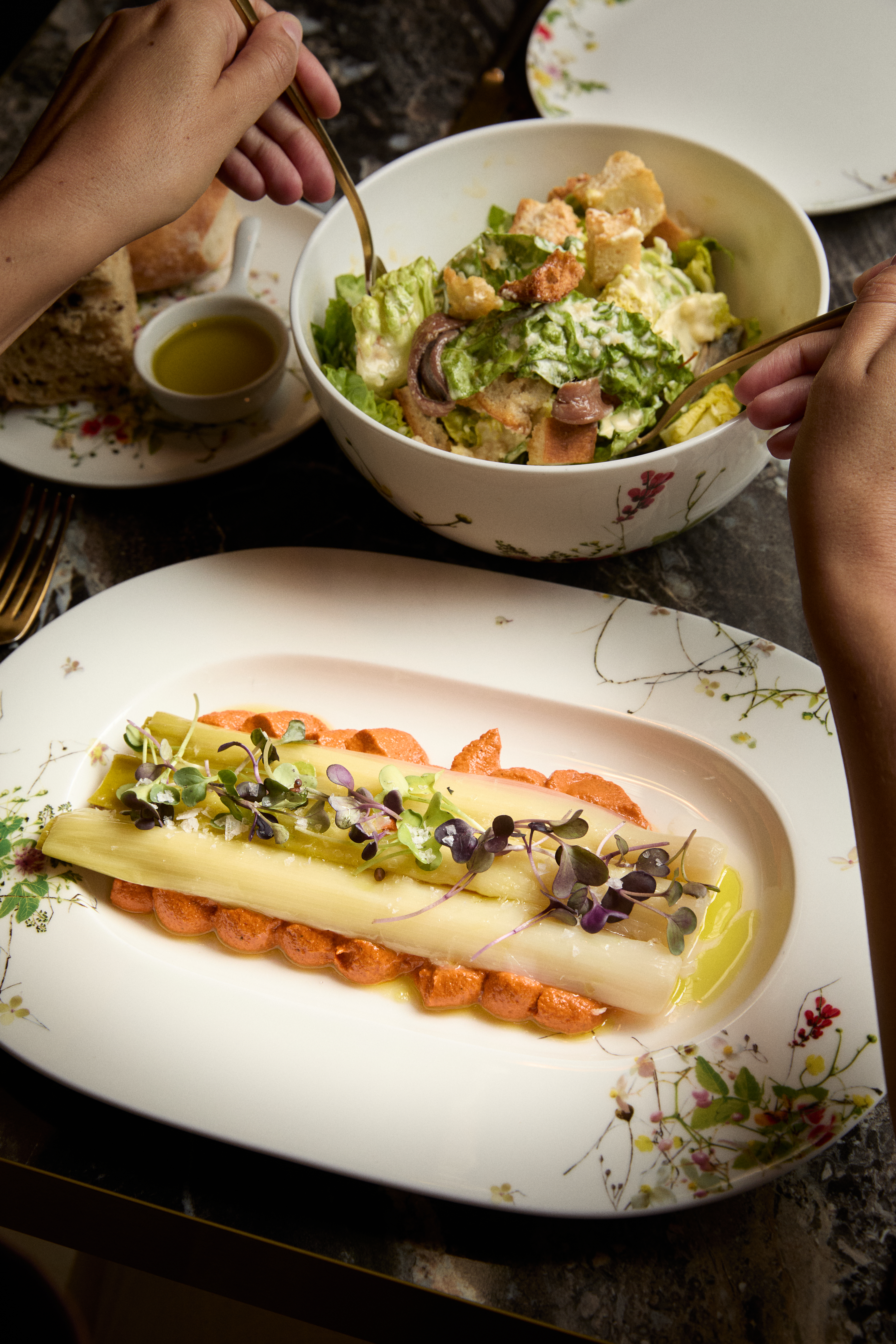 Gourmet white asparagus with red pepper sauce and Caesar salad, fine dining.