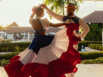 a man and woman dancing in a red white and blue dress