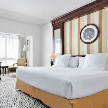 a bed with white sheets and a brown and white striped wall