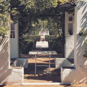 a white wall with a table and benches