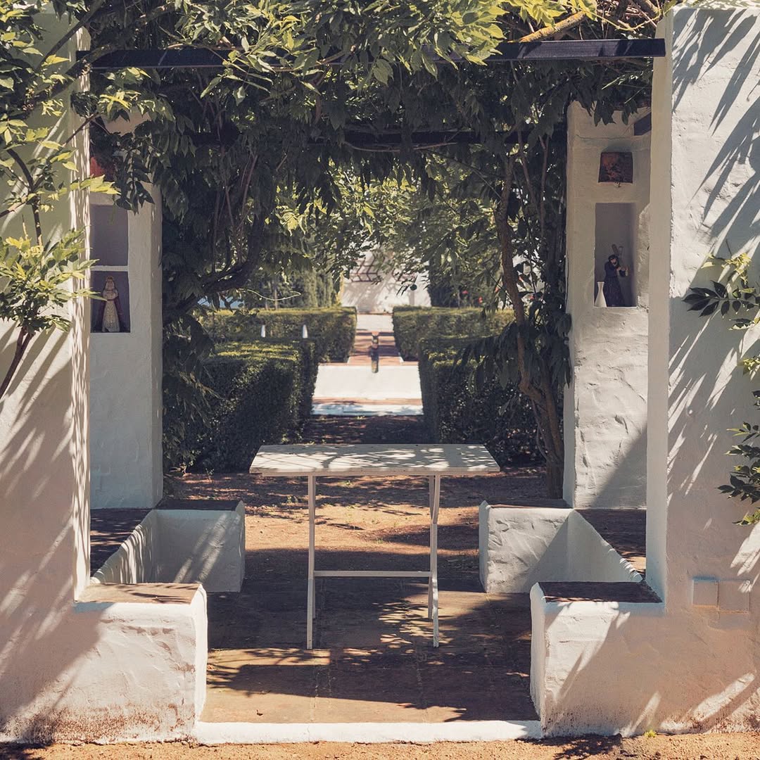 a white wall with a table and benches