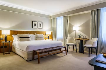 a bedroom with a bed and chairs