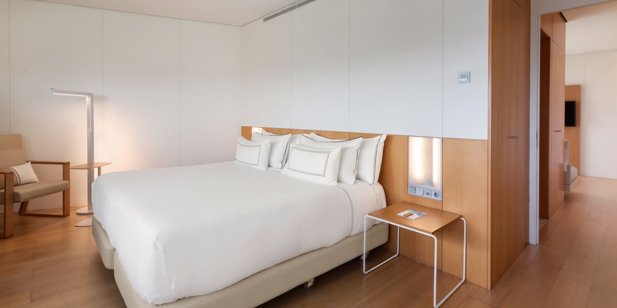 a bed with white sheets and a table