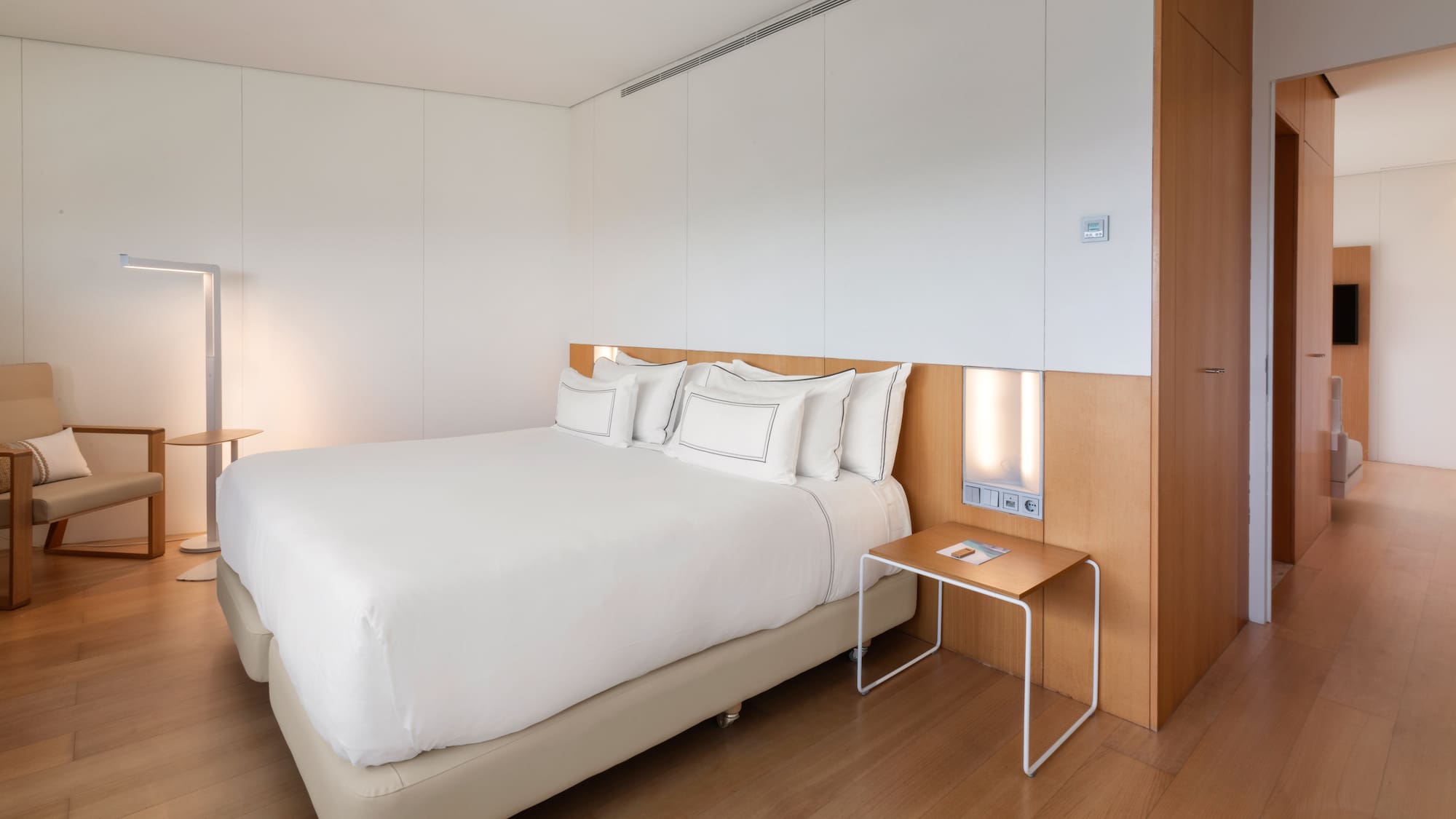 a bed with white sheets and a table