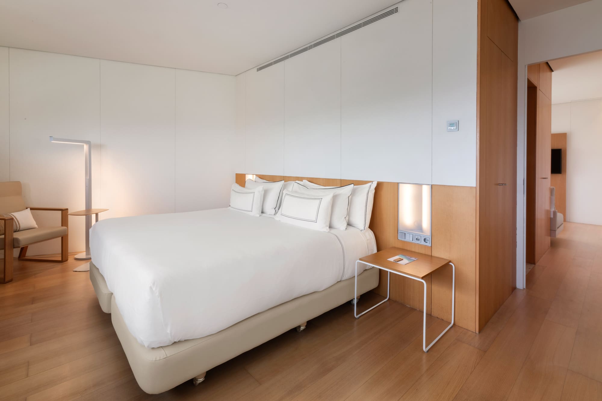 a bed with white sheets and a table