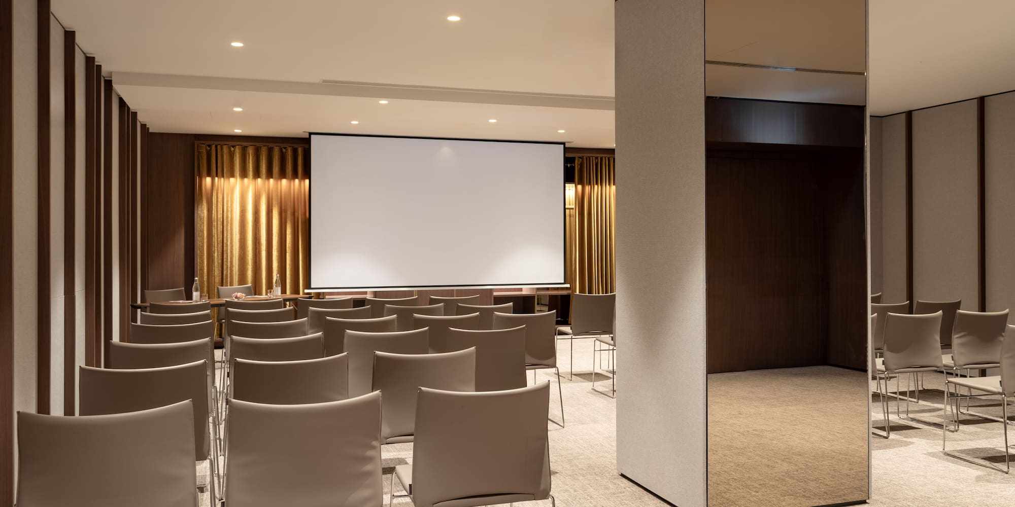 a room with a large screen and chairs