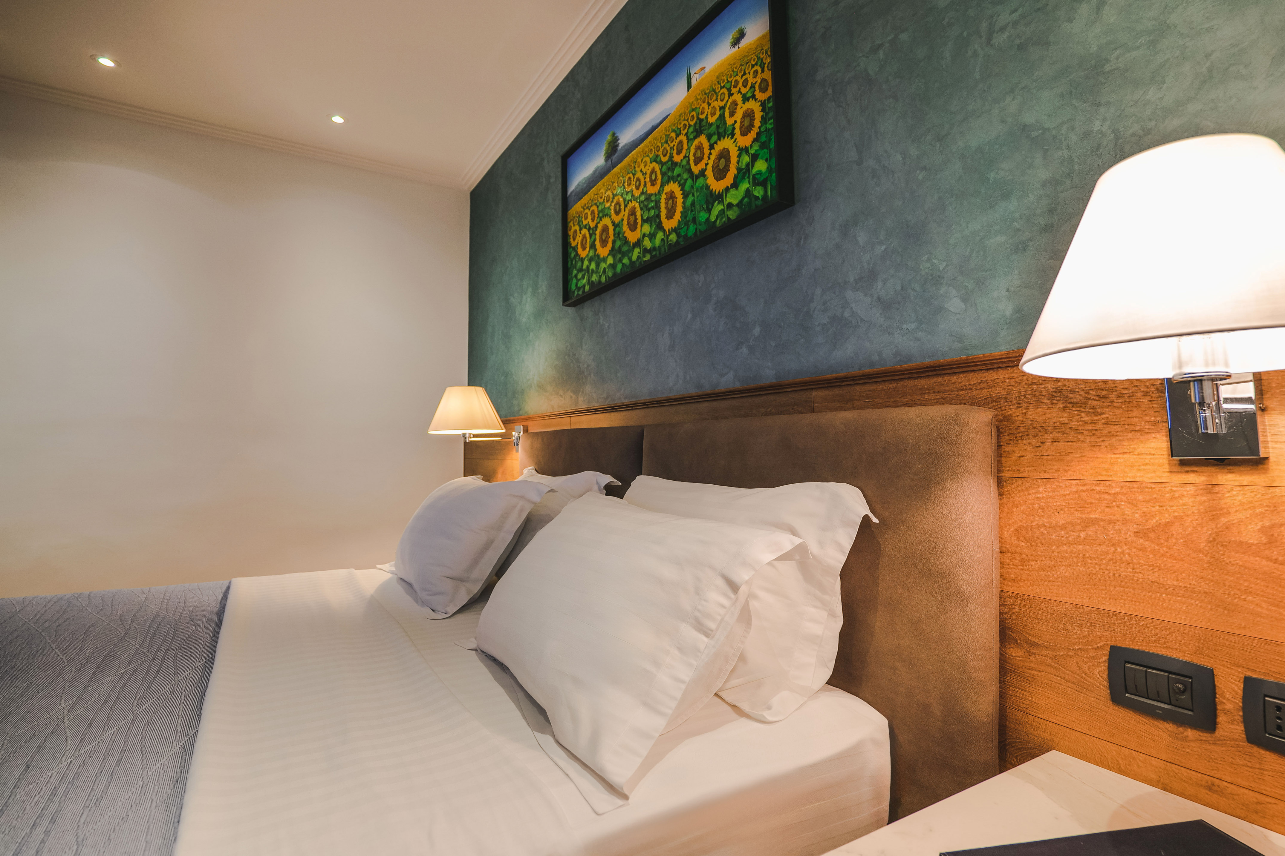 a bed with white pillows and lamps