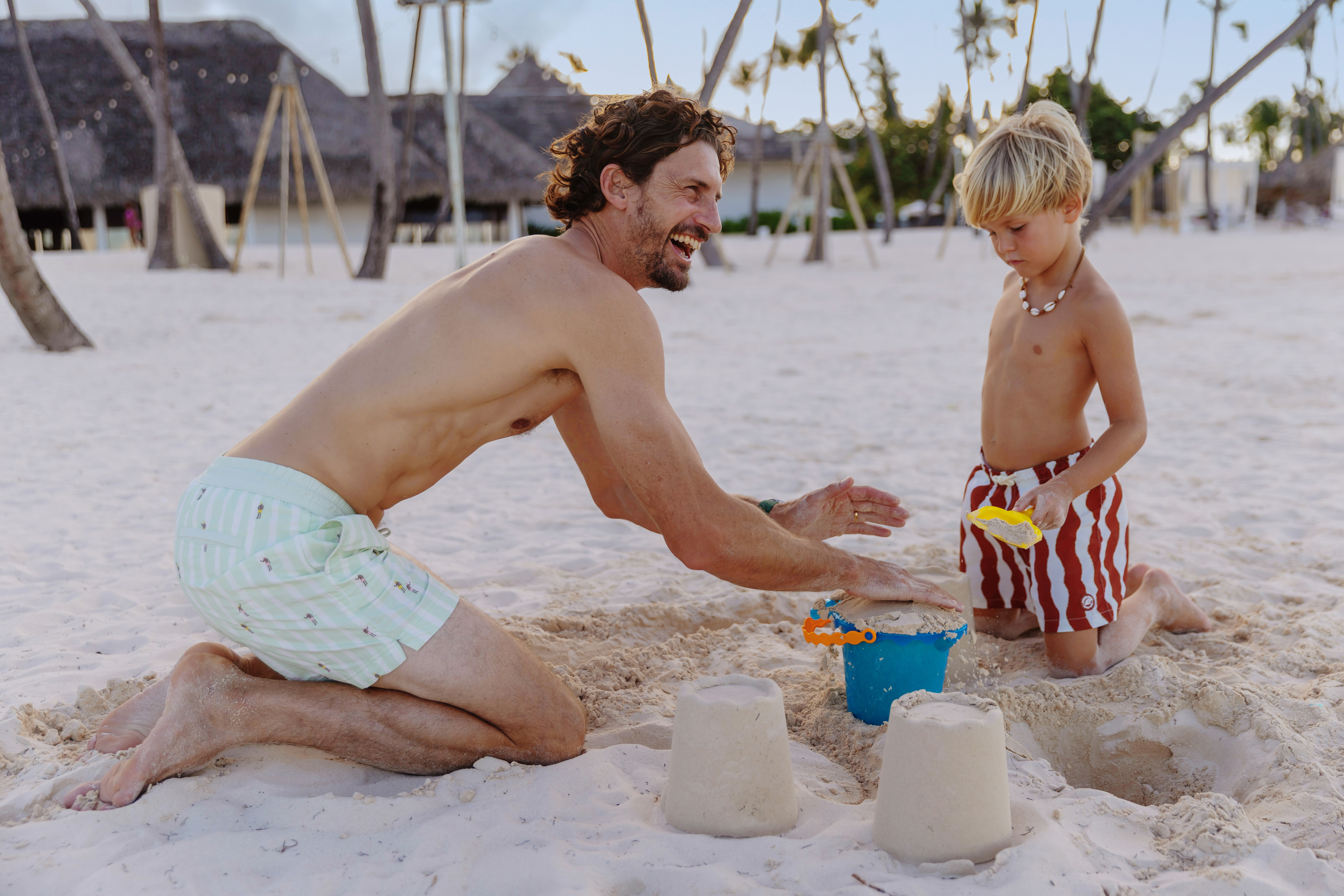 a man and boy playing with sand on a beach
