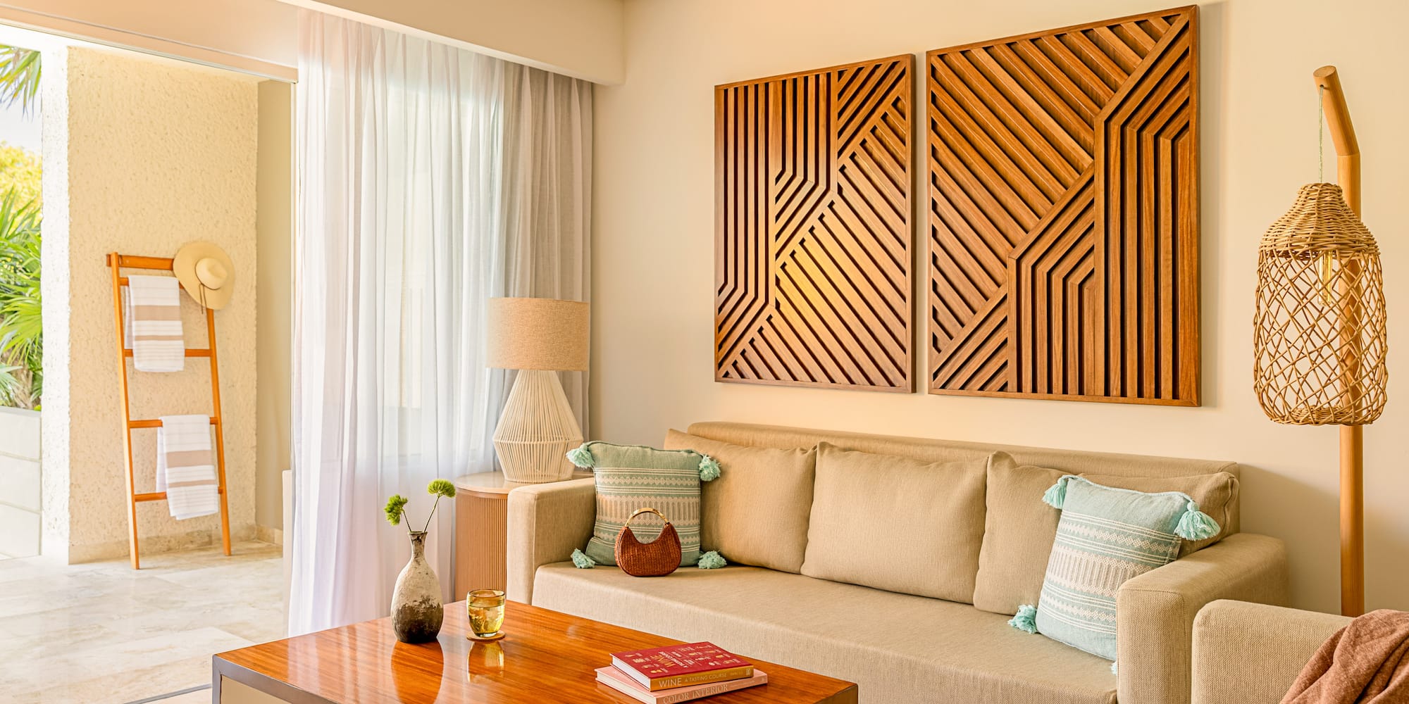 Resort living room with beige sofa, wood table, geometric art, and balcony.