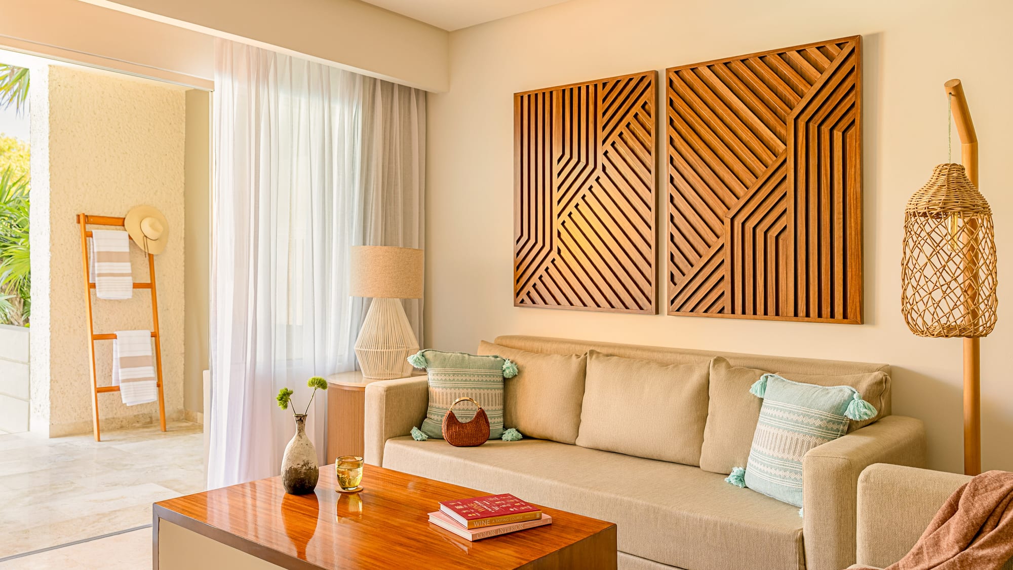 Resort living room with beige sofa, wood table, geometric art, and balcony.