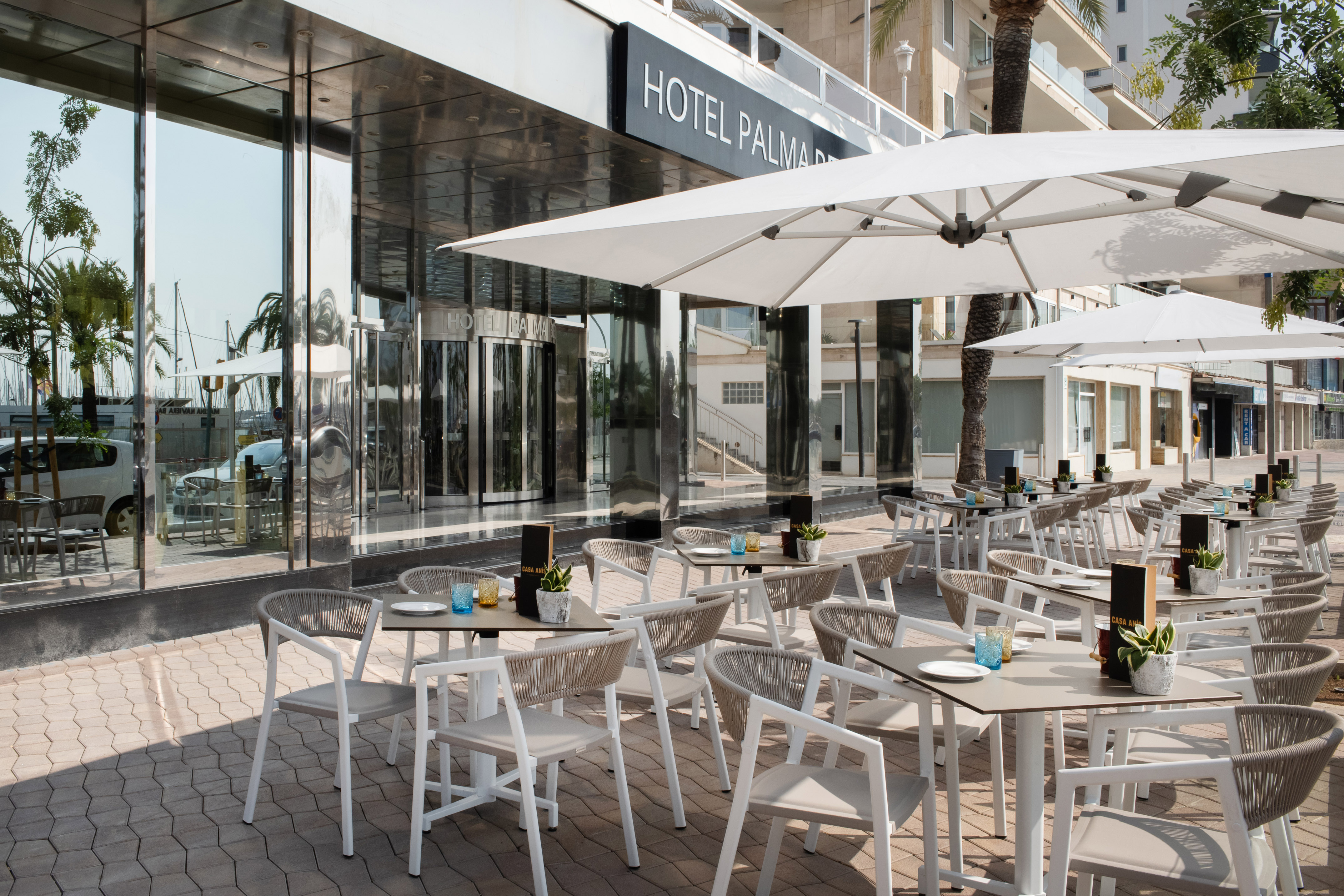 Hotel Palma outdoor restaurant terrace with modern seating and umbrellas.
