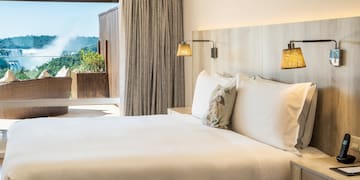 a bed with pillows and lamps in a room